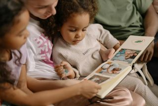 A loving family shares joyful moments bonding over a photo album.